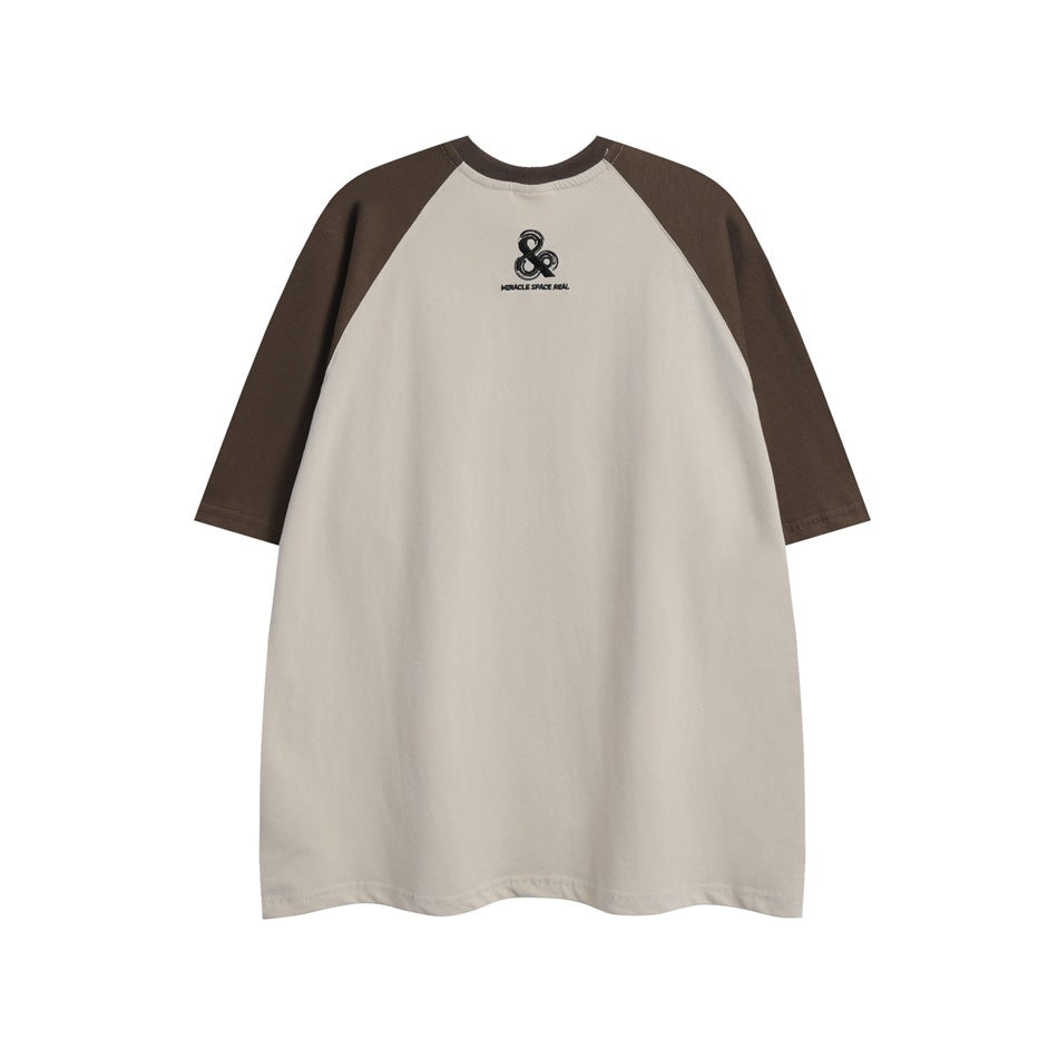 Front view of a light beige raglan T-shirt with dark brown sleeves and a small black chest emblem.