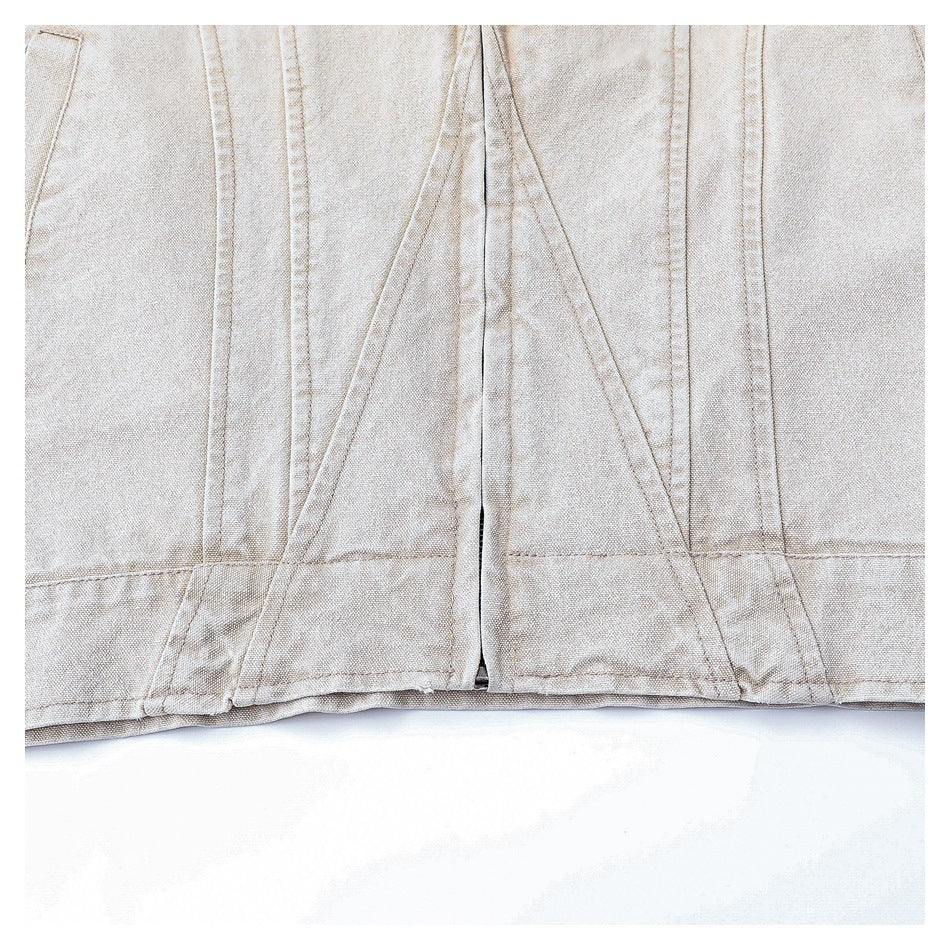 Close-up of the lower front of a light beige jacket, showing panel seams and the hem.