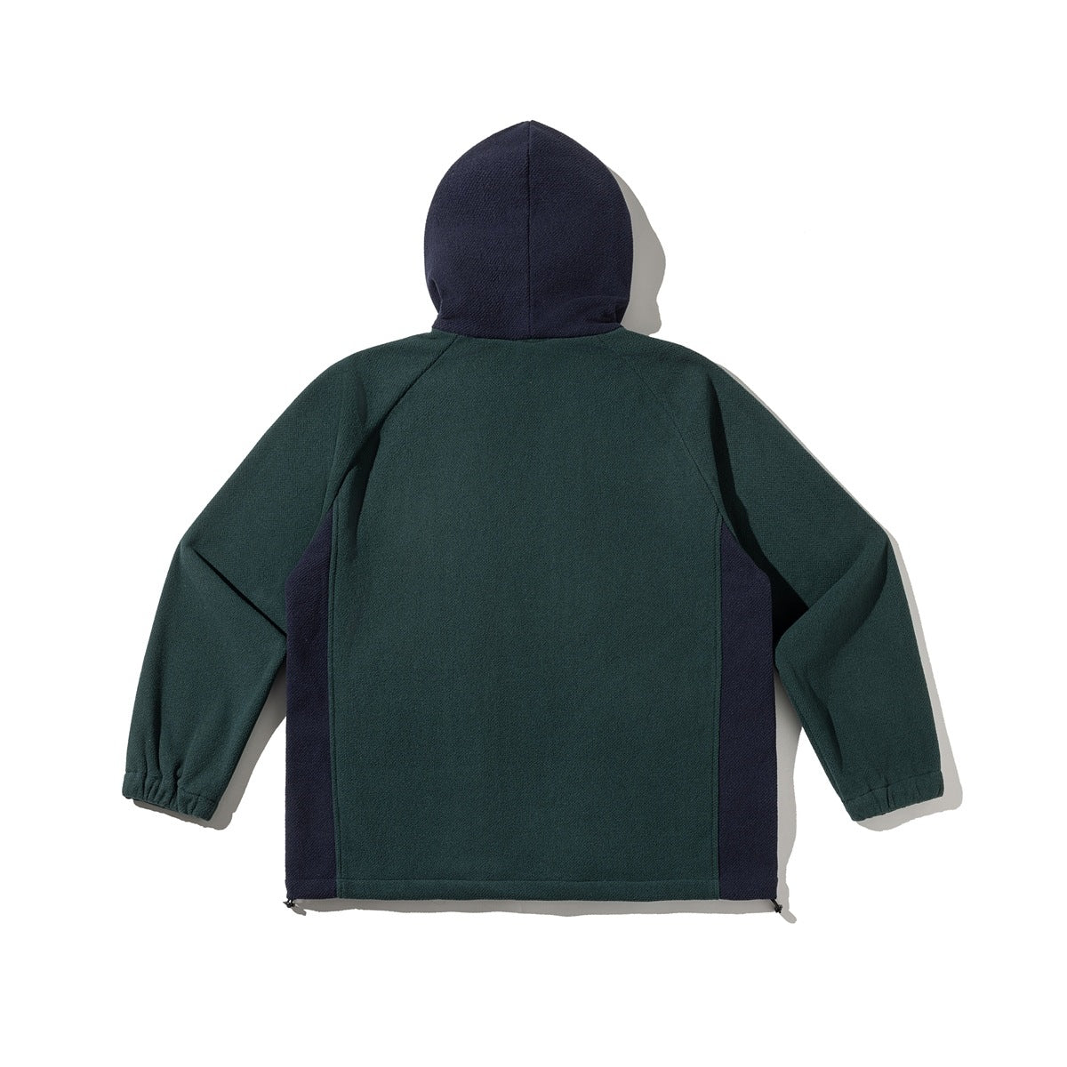 Back view of a dark teal hooded pullover jacket with navy side panels and a navy hood.