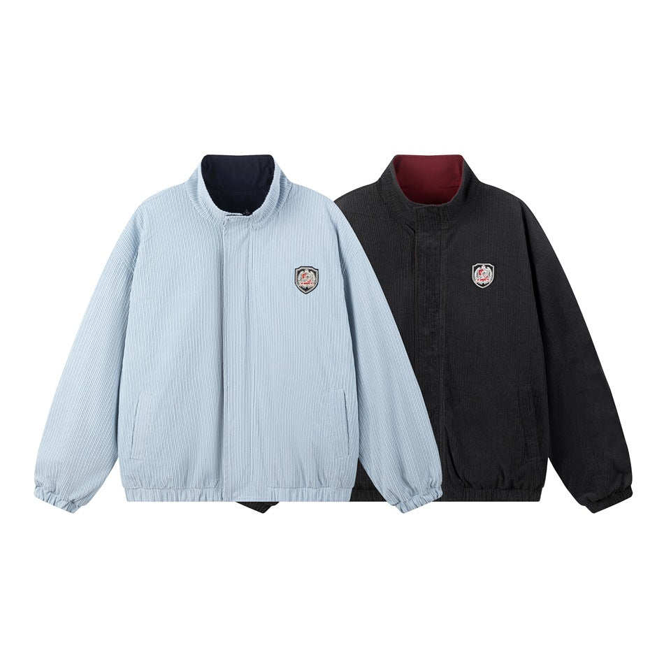 Two jackets shown together: pale blue pinstriped and charcoal, both with stand collars, chest patches, and elastic hems.