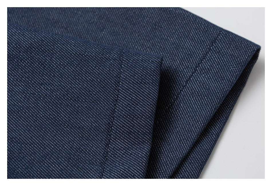 Close-up of dark navy fabric with fine diagonal texture and a folded, stitched edge.