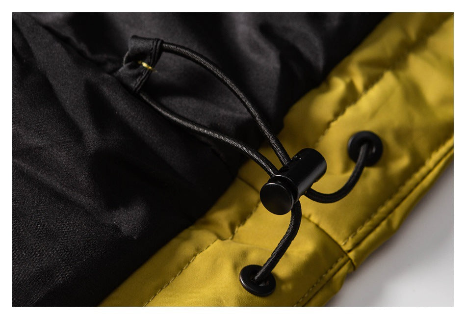 Close-up of a black drawcord toggle and eyelets on the mustard yellow and black jacket.