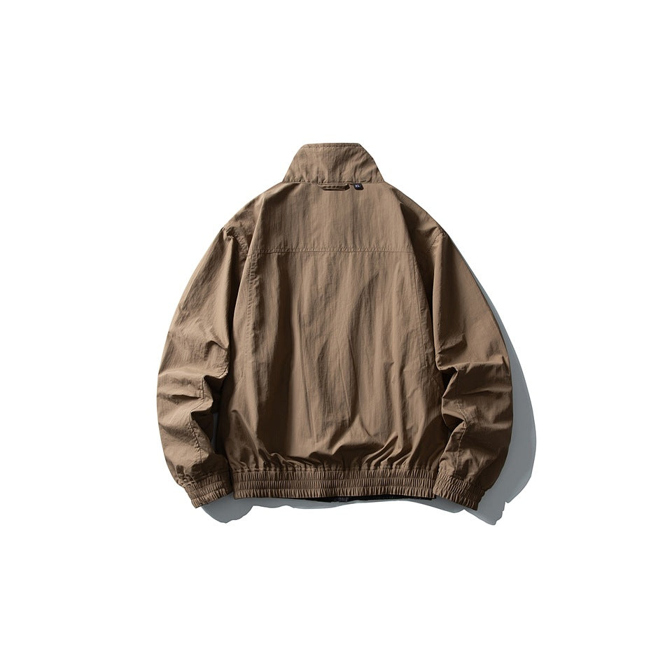 Taupe jacket shown from the back, with a raised collar and elastic cuffs and hem.