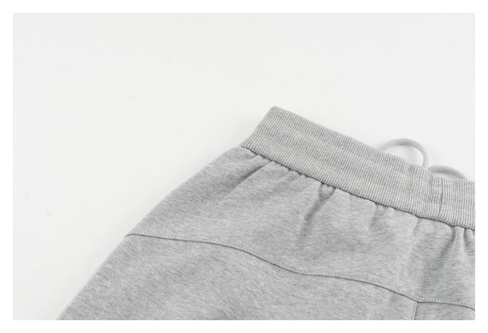 Close-up of a light gray garment waistband with a drawstring and stitched seams.