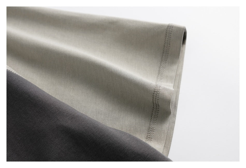 Close-up of light gray and charcoal fabric with a stitched edge.