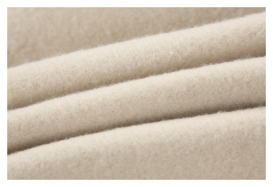 Extreme close-up of the soft, fuzzy beige fabric surface in folded layers.