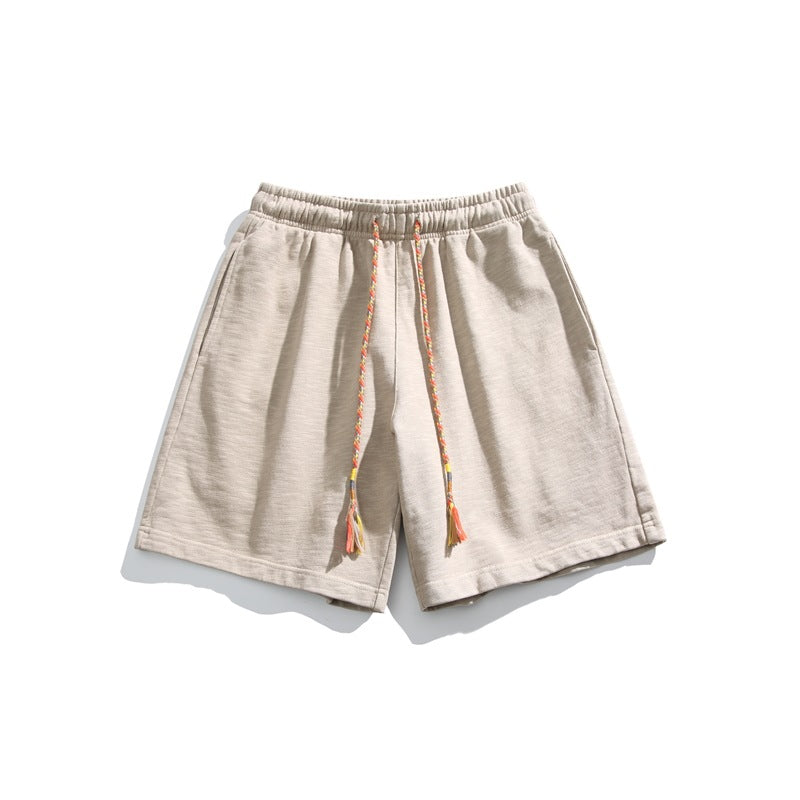Light linen beige knit shorts flat lay with braided multicolor drawstring and tassels