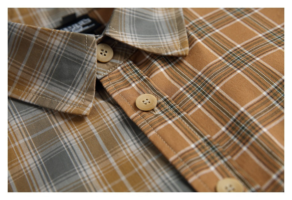 Close-up of overlapping gray and camel plaid shirts, showing the collar, contrasting checks, and tan buttons.