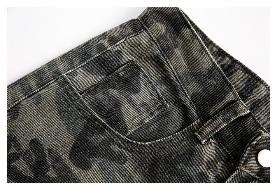 Close-up of a rear patch pocket, waistband, and belt loop on dark camouflage pants.