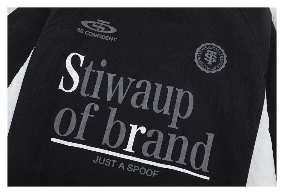 Close-up of the top’s chest print: large gray and white lettering, small emblems, and off-white side panels.
