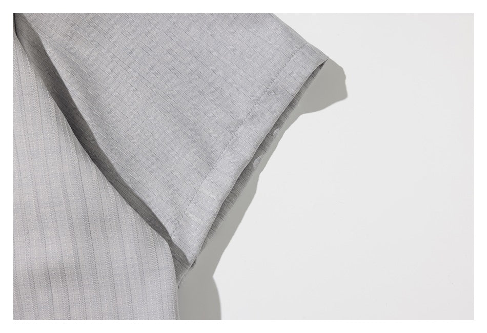 Close-up of the pale gray garment's short sleeve and stitched cuff.