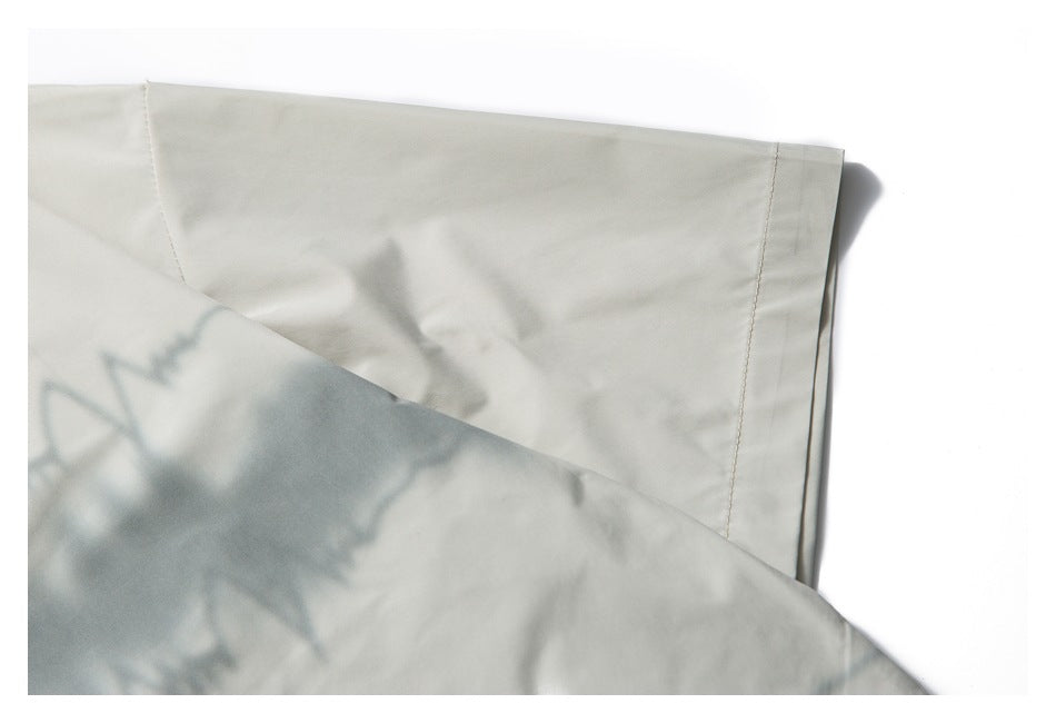 Close-up of an off-white shirt sleeve and stitched cuff with soft shadows.