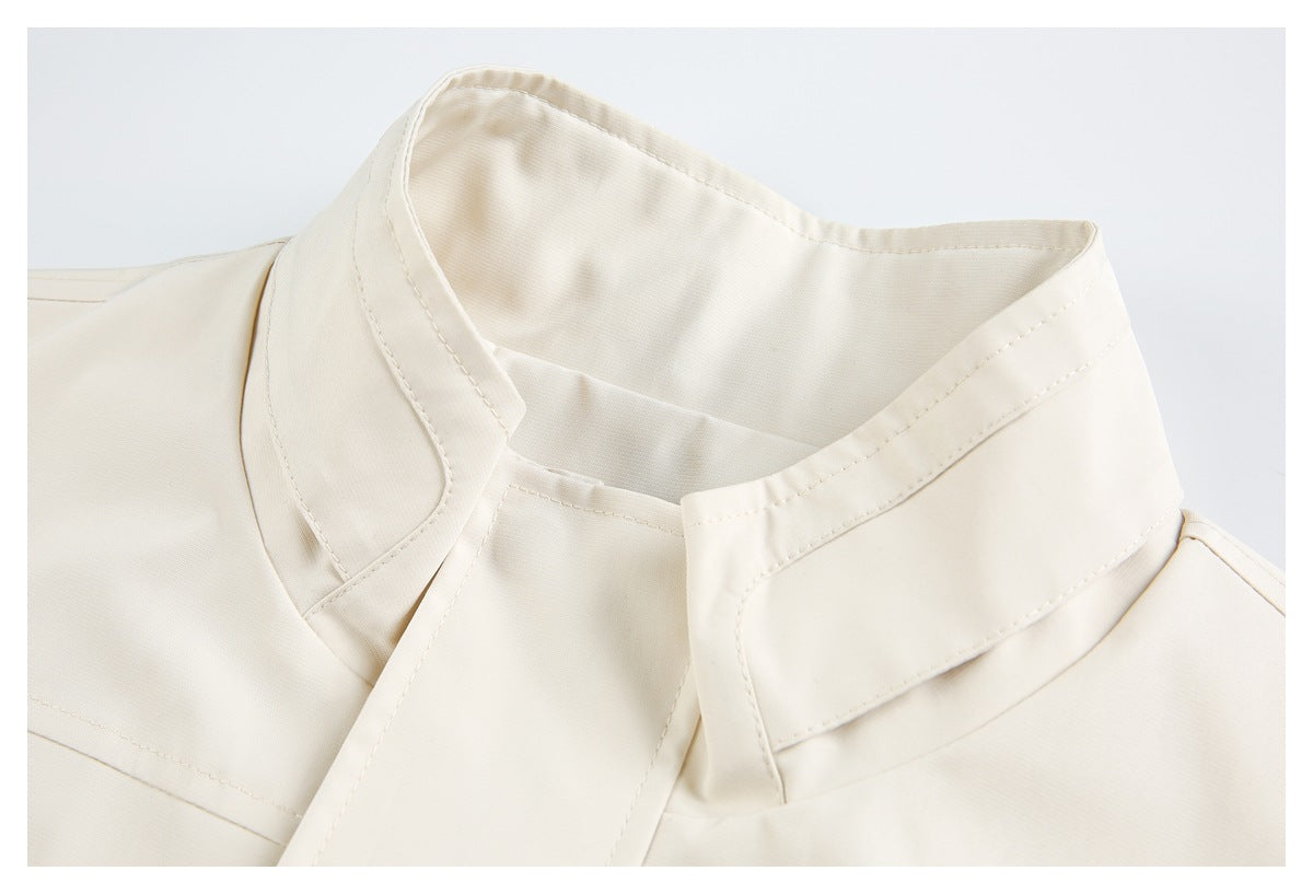 Close-up of the cream jacket's stand collar, neckline, and visible stitching.