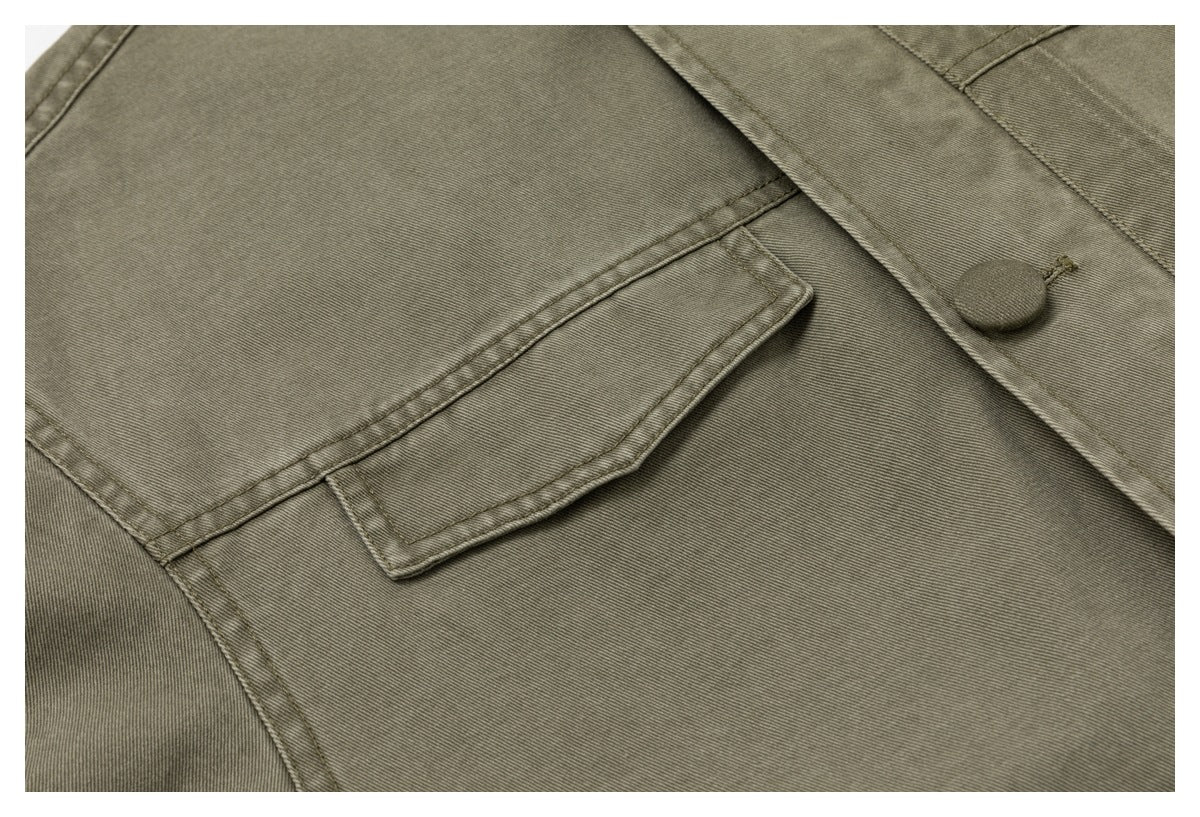 Close-up of a flap pocket and covered button on the olive-gray jacket's front.