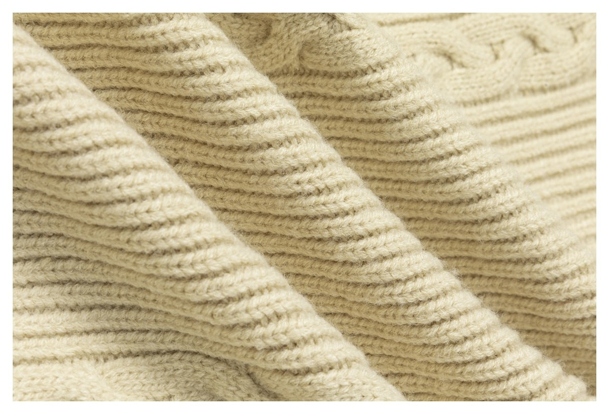Macro view of the cream knit garment's raised ribbed texture.