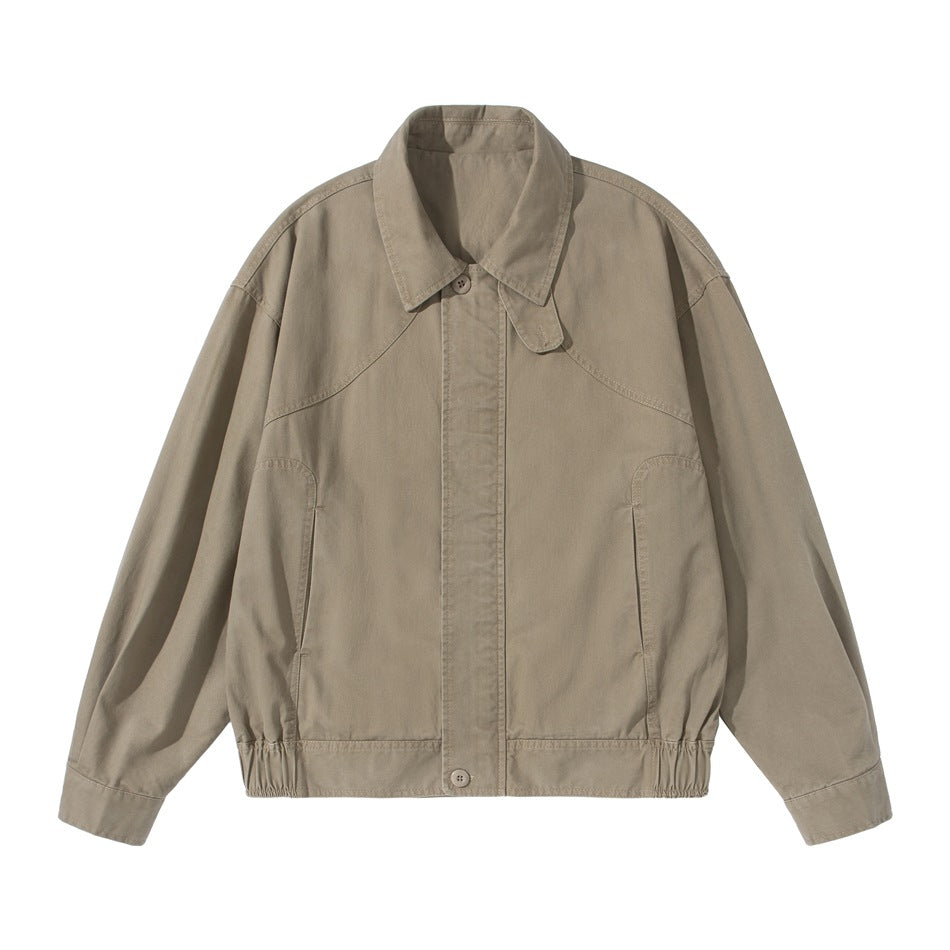 Khaki collared short jacket with curved yoke seams, slanted pockets and elastic hem, front flat lay