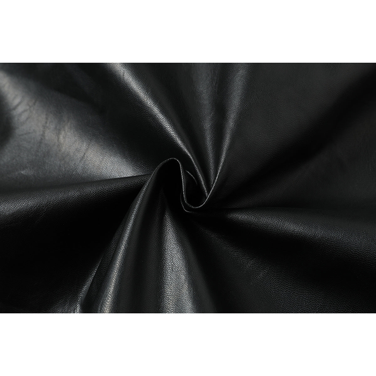 Close-up of black textured jacket material gathered into soft folds.
