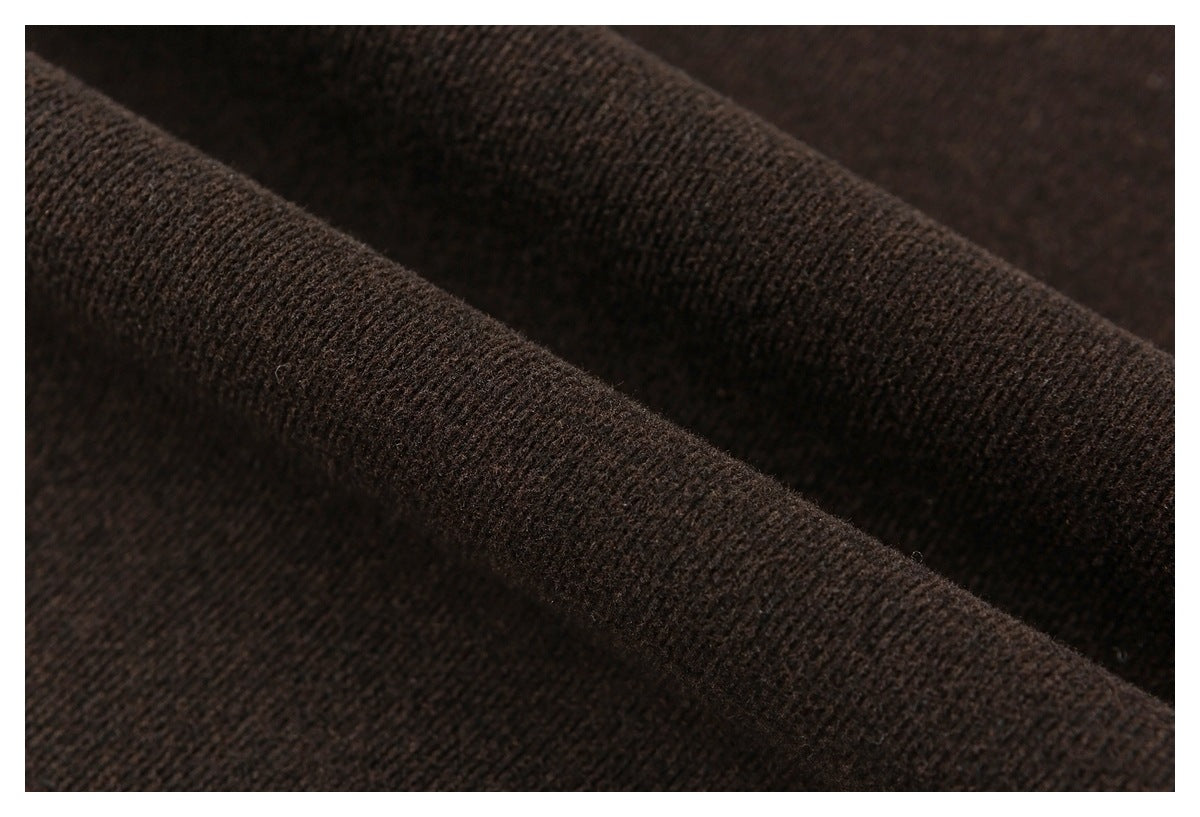 Macro view of the dark brown pants' textured fabric folded into a ridge.