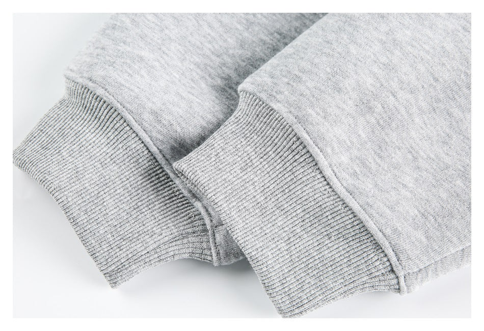 Close-up of two ribbed cuffs on light heather-gray sweatshirt sleeves.