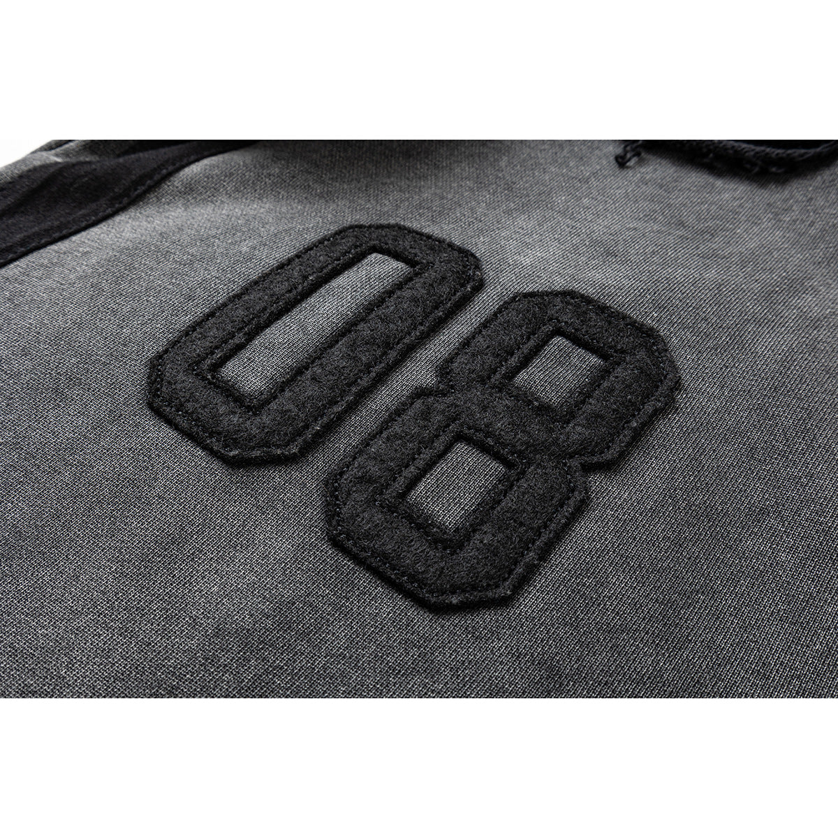 Close-up of a raised black number applique on charcoal-gray fabric.