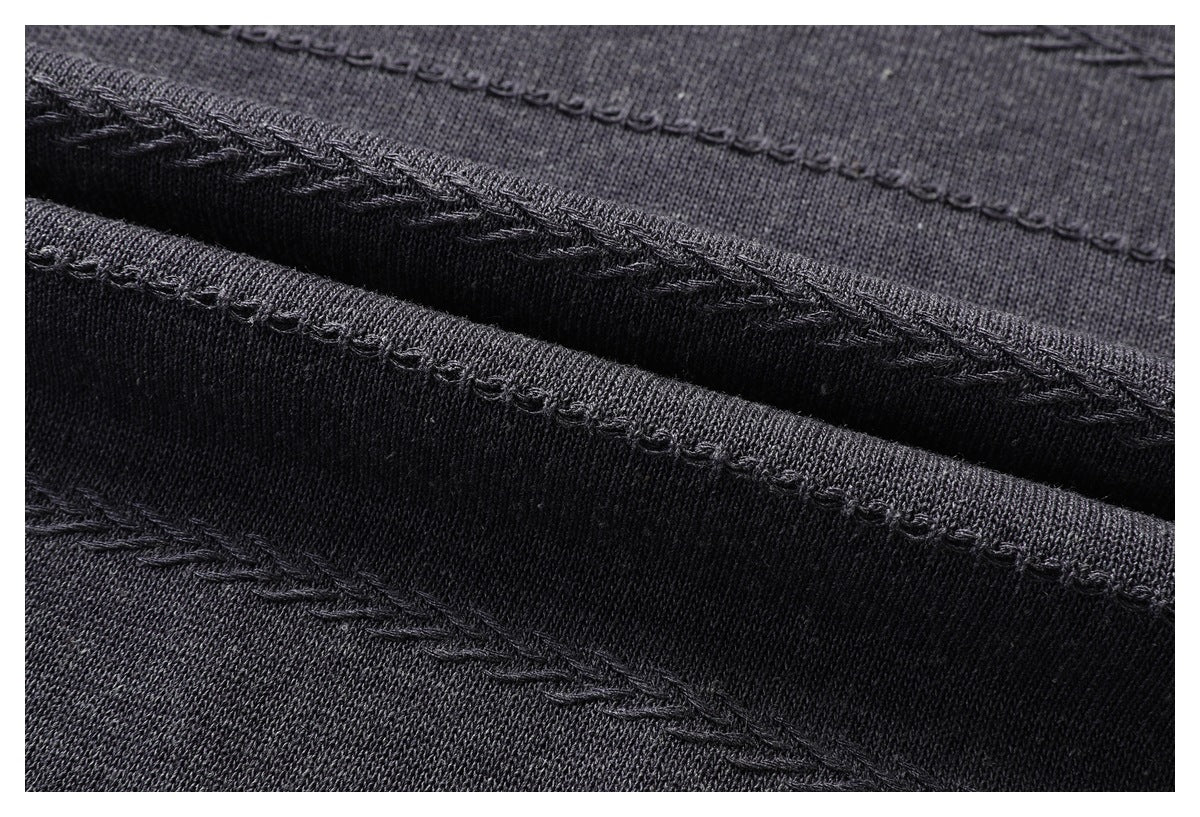 Close-up of folded charcoal knit fabric showing stitched edges and seam construction.