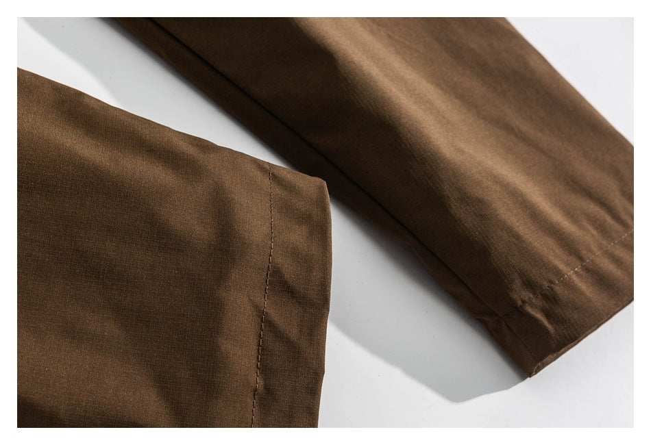 Close view of the brown jacket's sleeve and hem edges with visible stitching.
