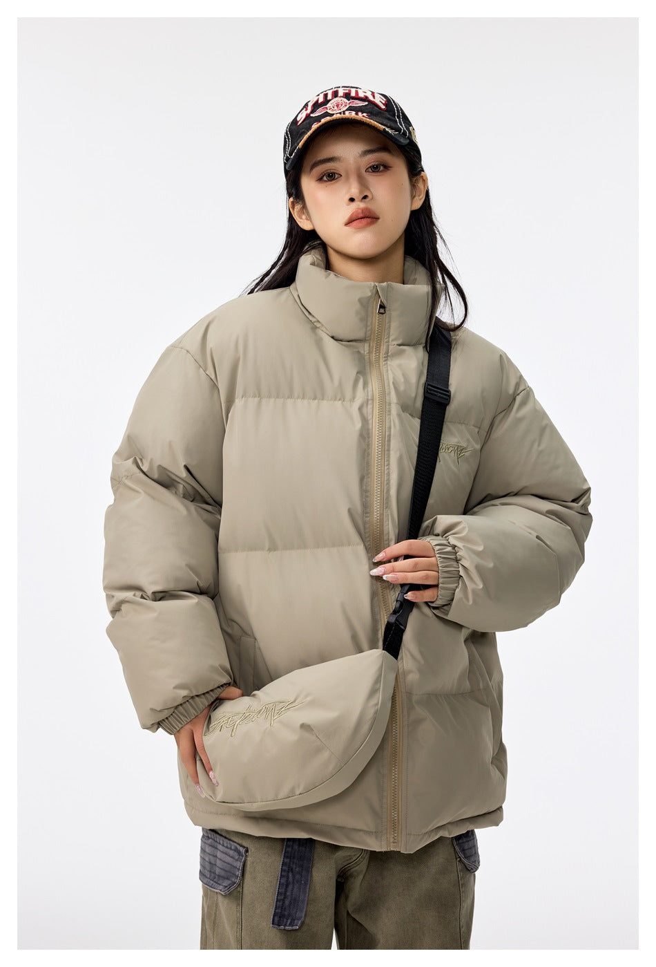 Woman modeling a taupe puffer jacket and matching crossbody bag, shown from the front.