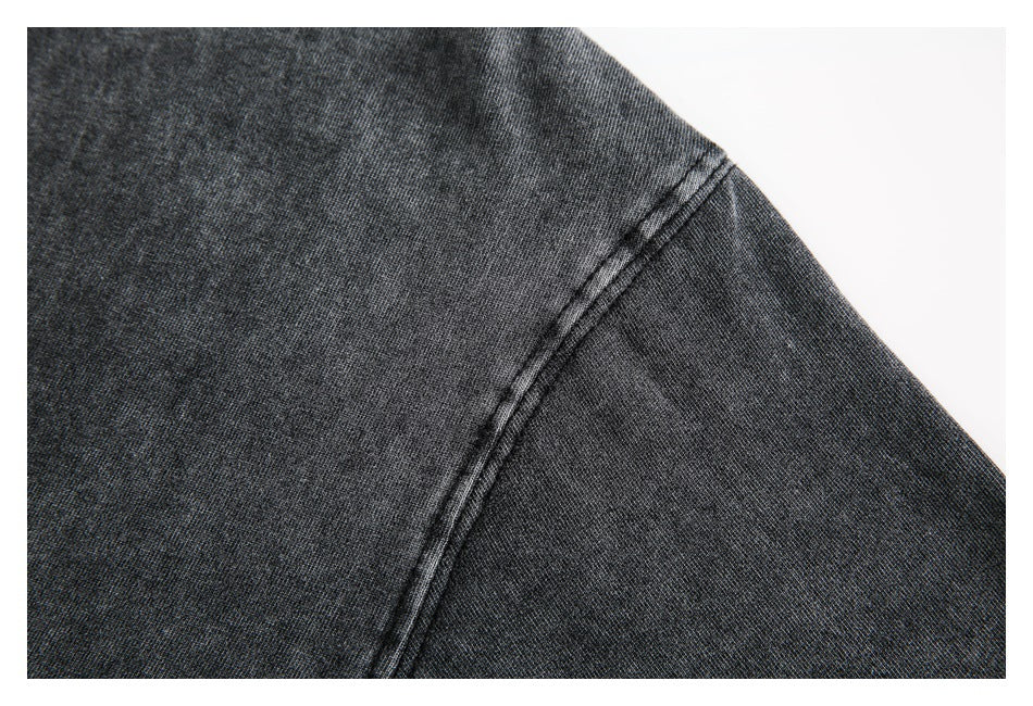 Close-up of the shoulder seam on a charcoal garment.