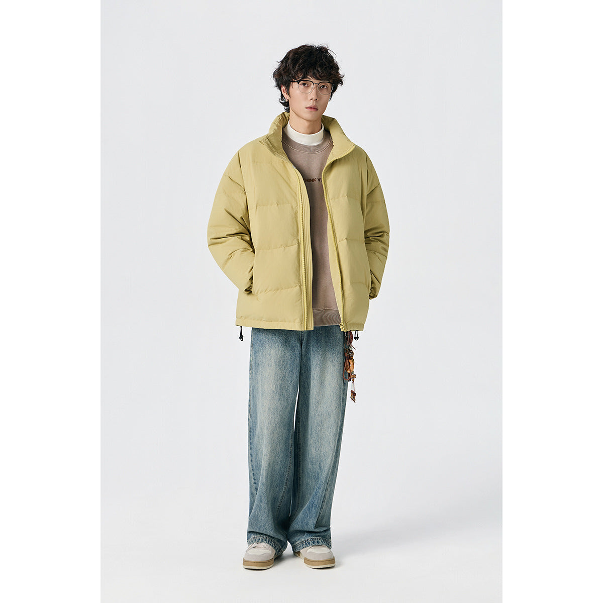 Model wearing a pale yellow padded jacket with a stand collar and front zipper, shown from the front.