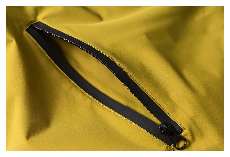 Close-up of a long black zipper set into mustard yellow jacket fabric.