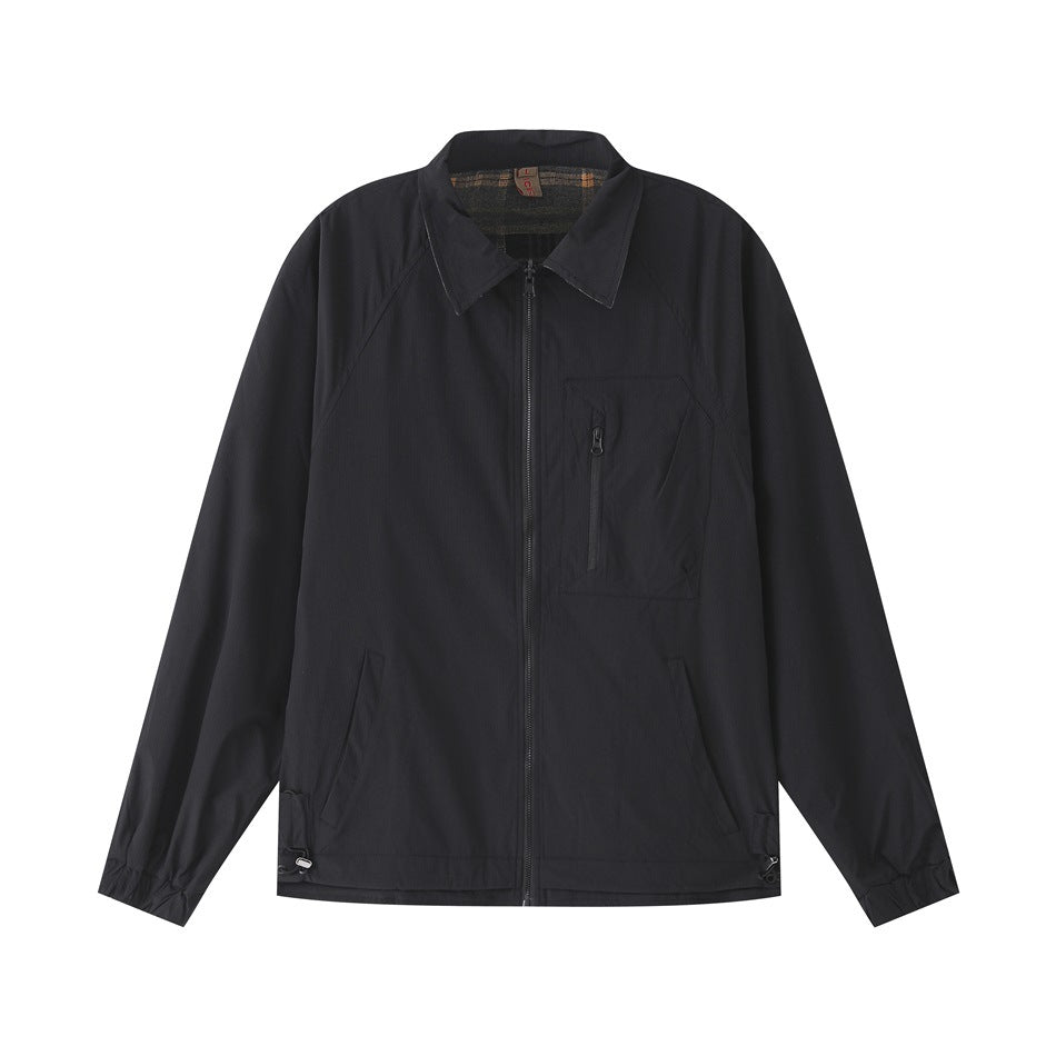 Black zip-front jacket with pointed collar, zippered chest pocket and plaid collar interior, flat lay front view