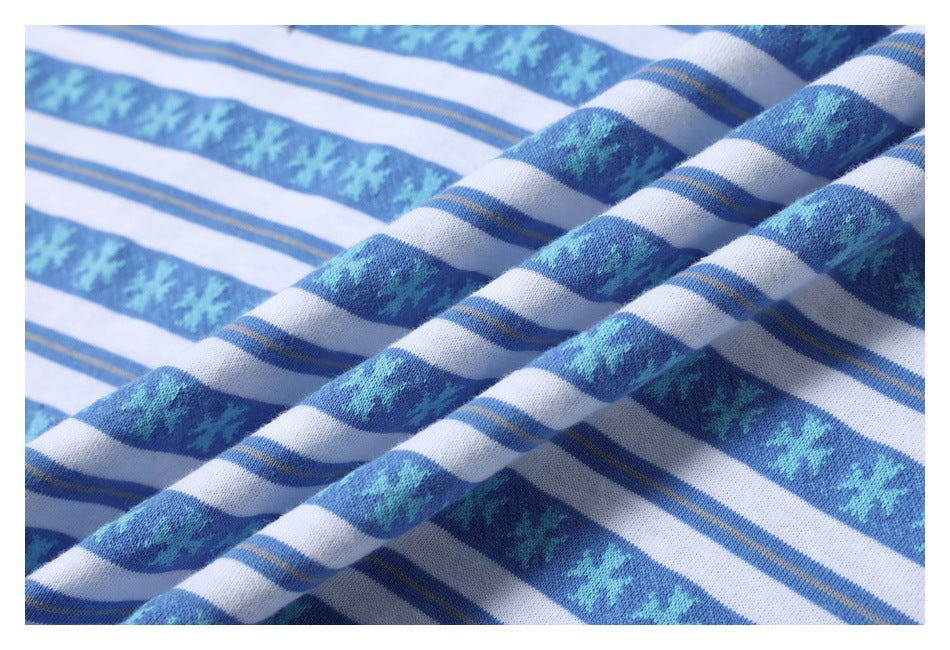 Close-up of blue and white striped knit fabric with turquoise geometric motifs and fine tan accent lines.