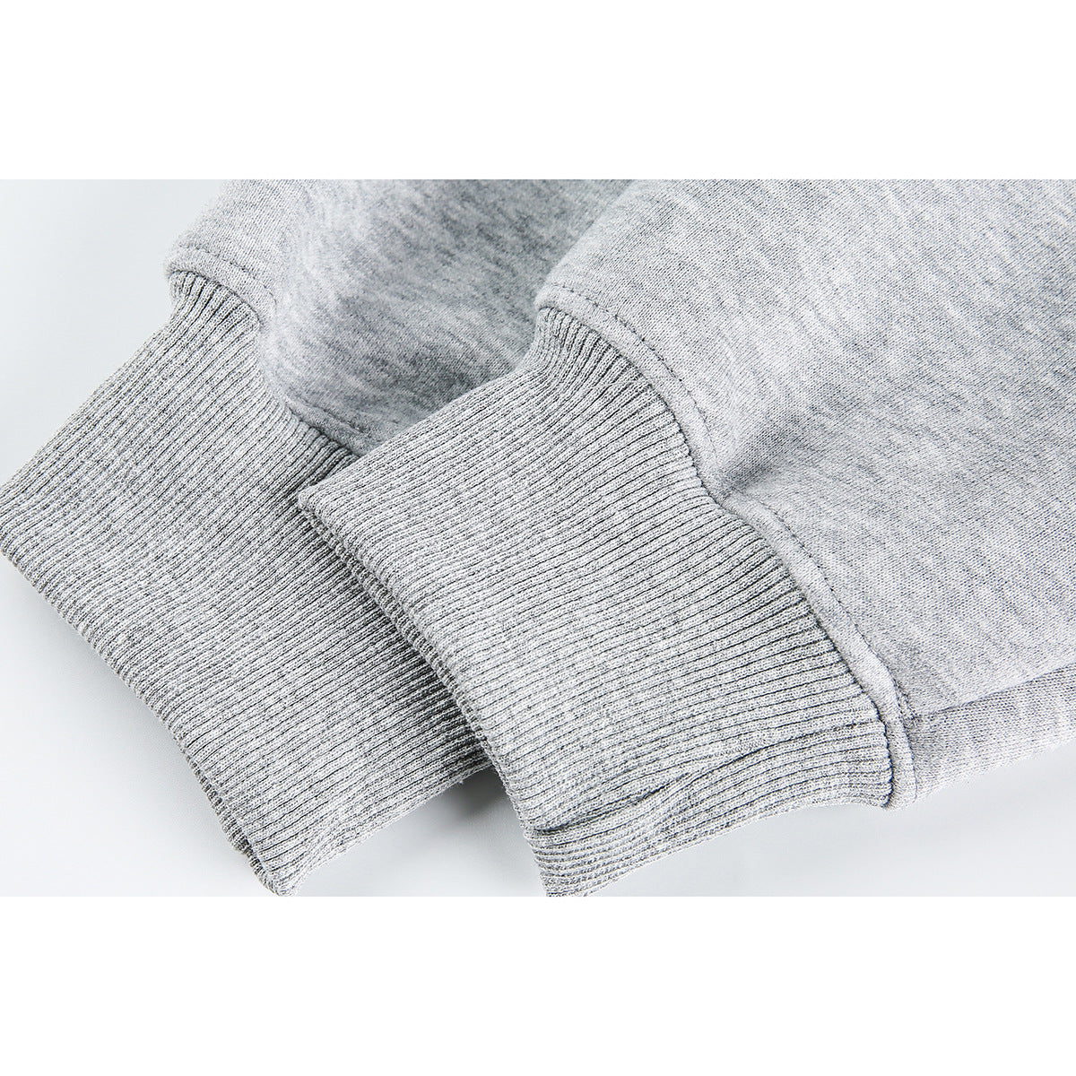 Close-up of ribbed cuffs on a light gray hoodie.