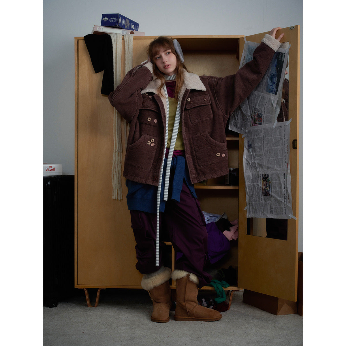 Model wearing a brown shearling-collar jacket with large pockets and small floral embellishments.