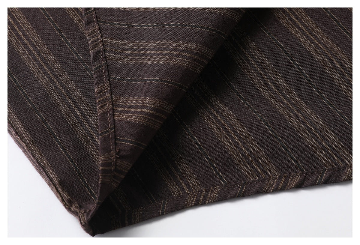 Close-up of a dark brown garment with fine tan stripes, showing a folded seam and finished edge.