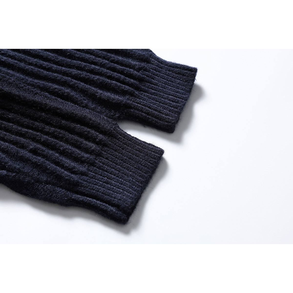 Close-up of two ribbed sleeve cuffs on the dark navy cardigan.
