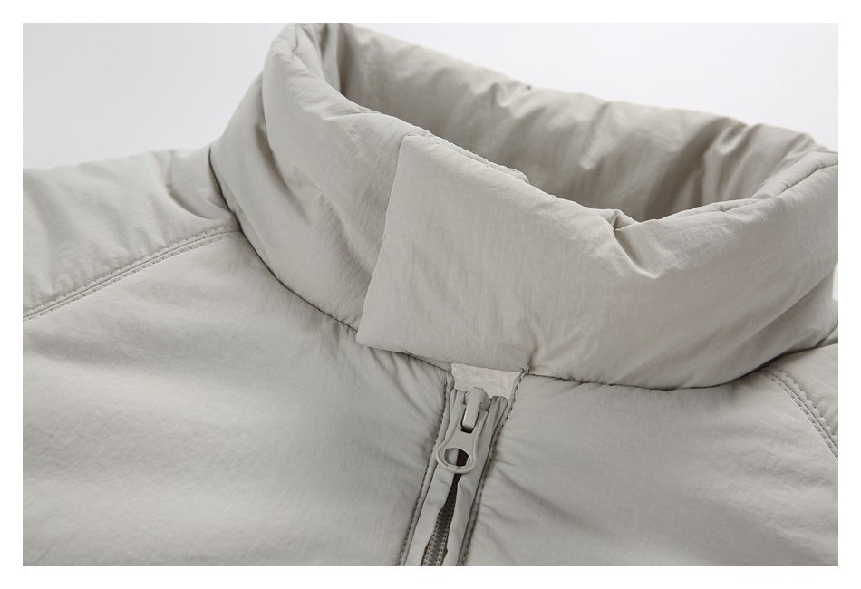 Close-up of a light gray-beige padded jacket collar and front zipper.