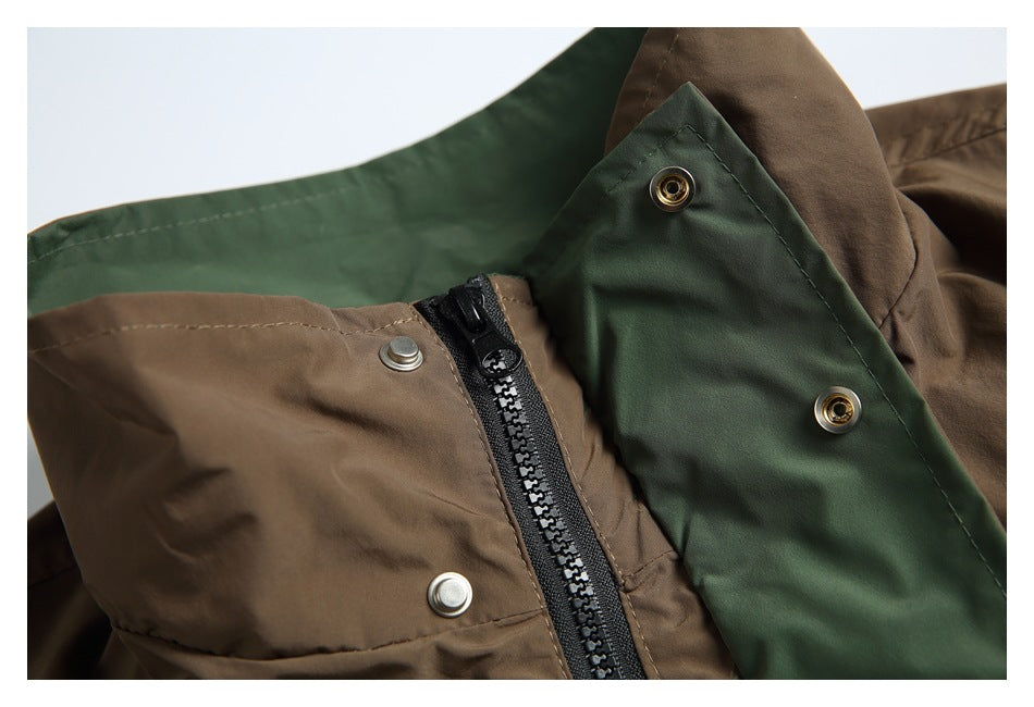 Close-up of a brown and dark green jacket with a front zipper, snap fasteners, and inner storm flap.