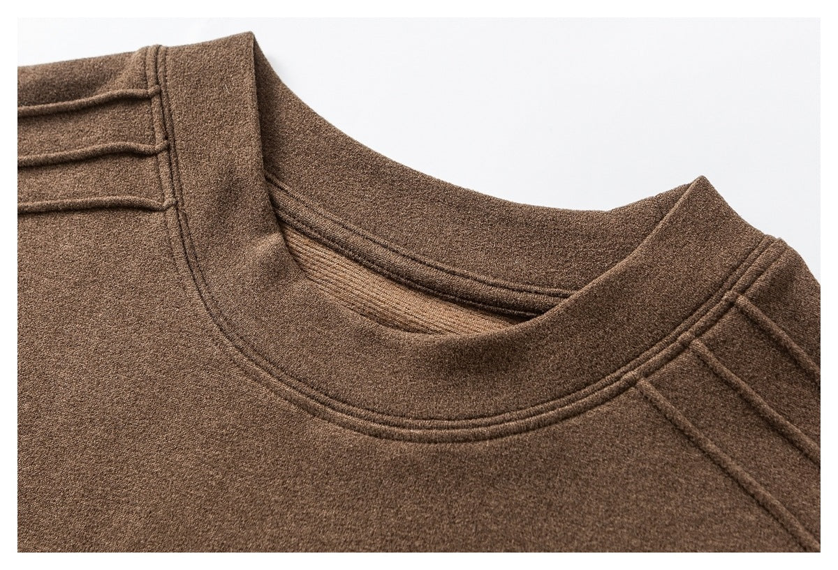 Close-up of a brown knit top's crew neckline and stitched shoulder seams.