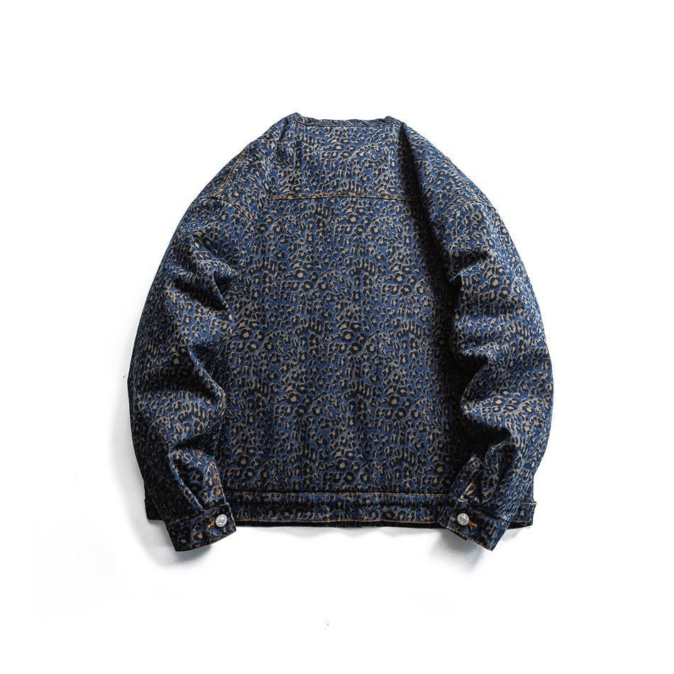 Back view of a blue leopard-print denim jacket laid flat, with long sleeves and orange contrast stitching.