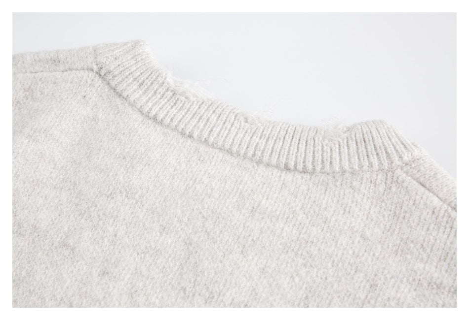 Close-up of the ribbed crew neckline on an ivory fuzzy knit sweater.