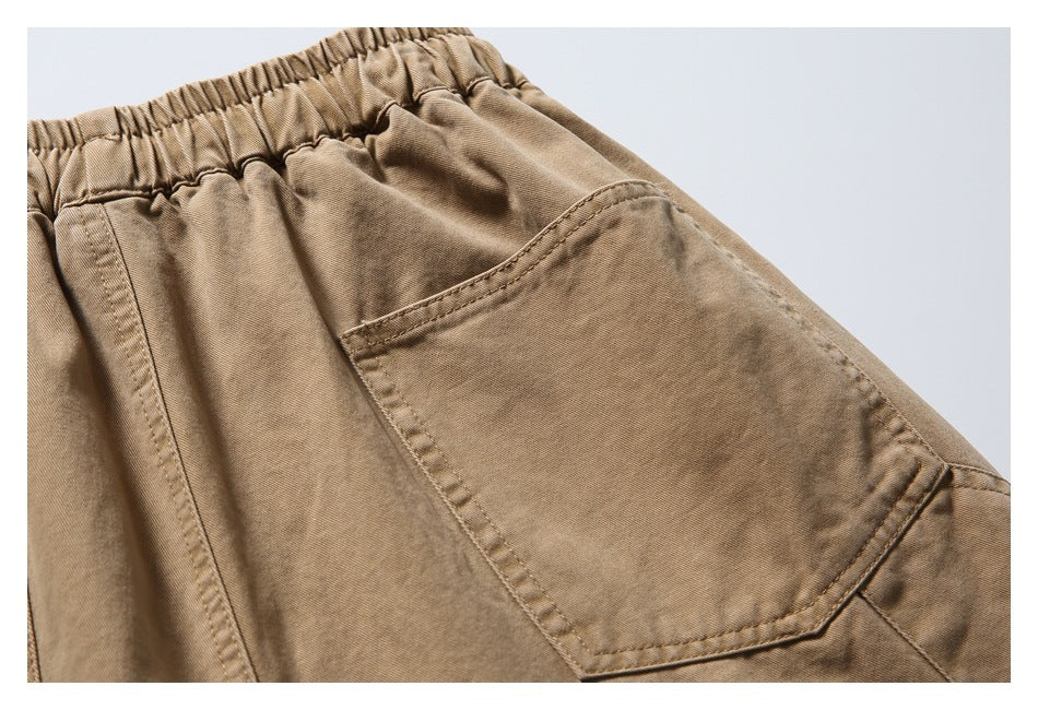 Close-up of a stitched patch pocket and gathered waistband on the tan bottoms.