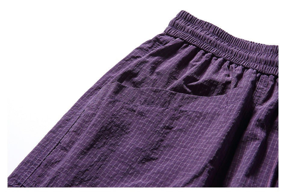 Close-up of a rear pocket and the purple shorts' dark irregular pattern over a fine grid.