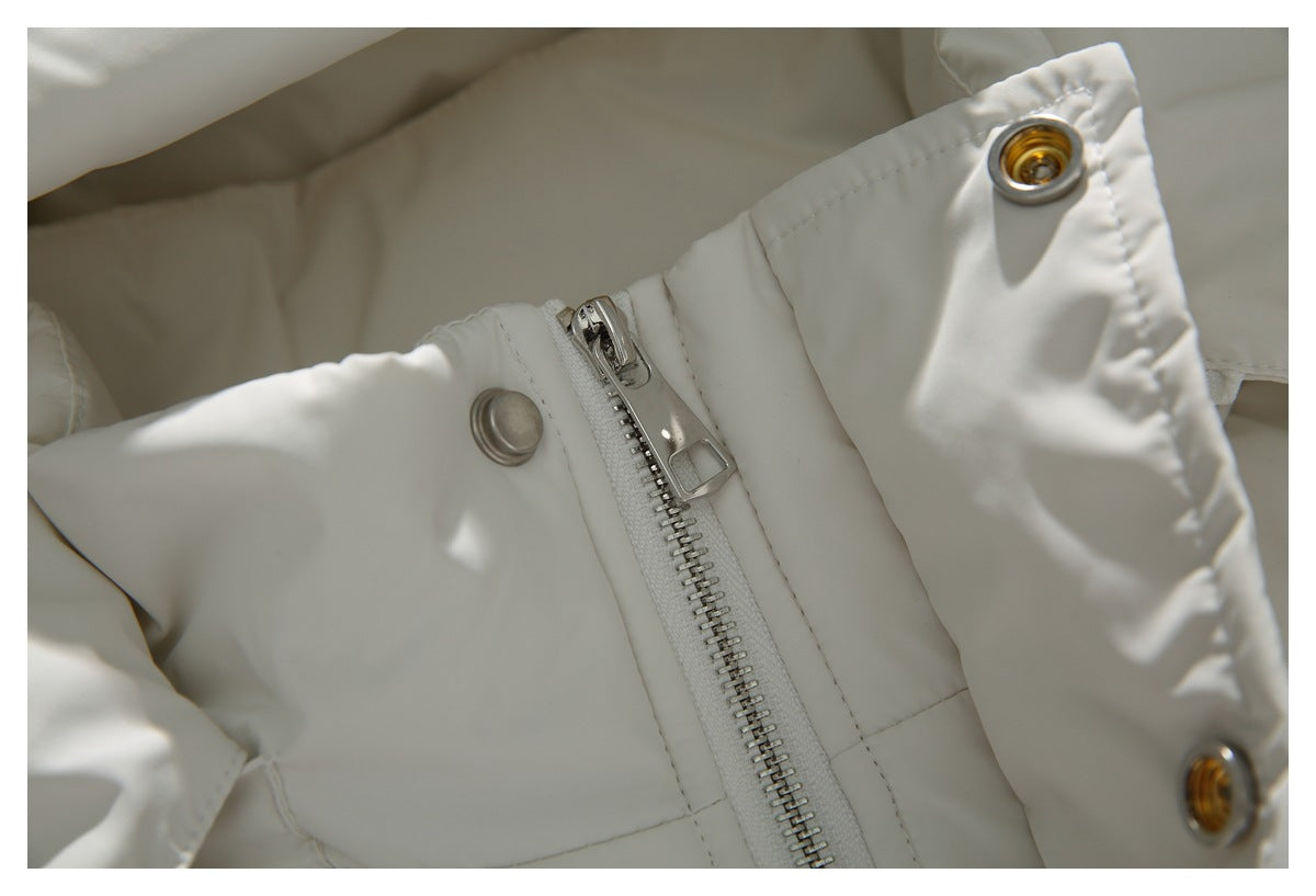 Close-up of the white coat's silver zipper and metal snaps on the front placket.