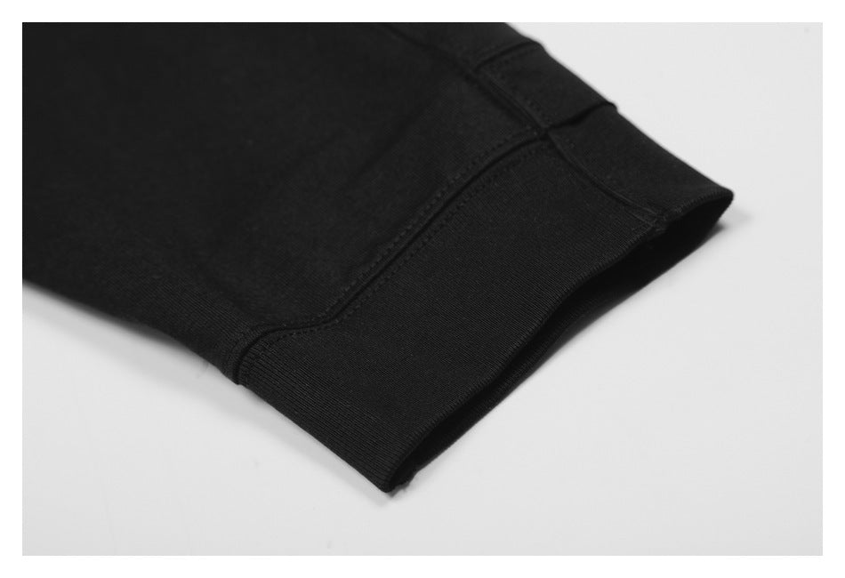 Close-up of a black sleeve cuff with a wide stitched band.