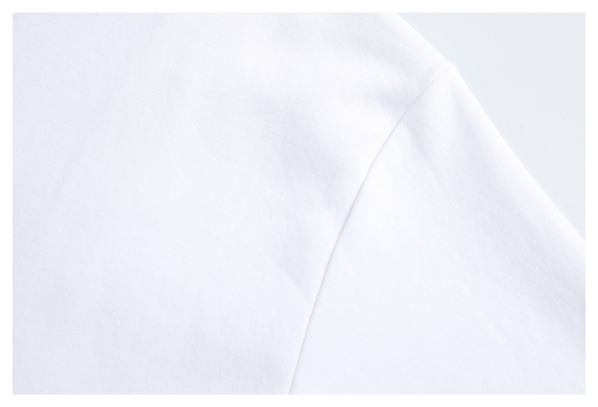 Close-up of a white garment's shoulder seam and sleeve.