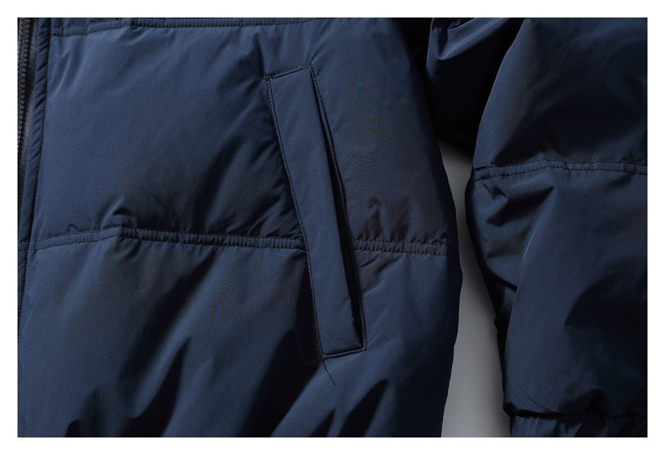 Close-up of a vertical welt pocket and horizontal stitching on the dark navy jacket.