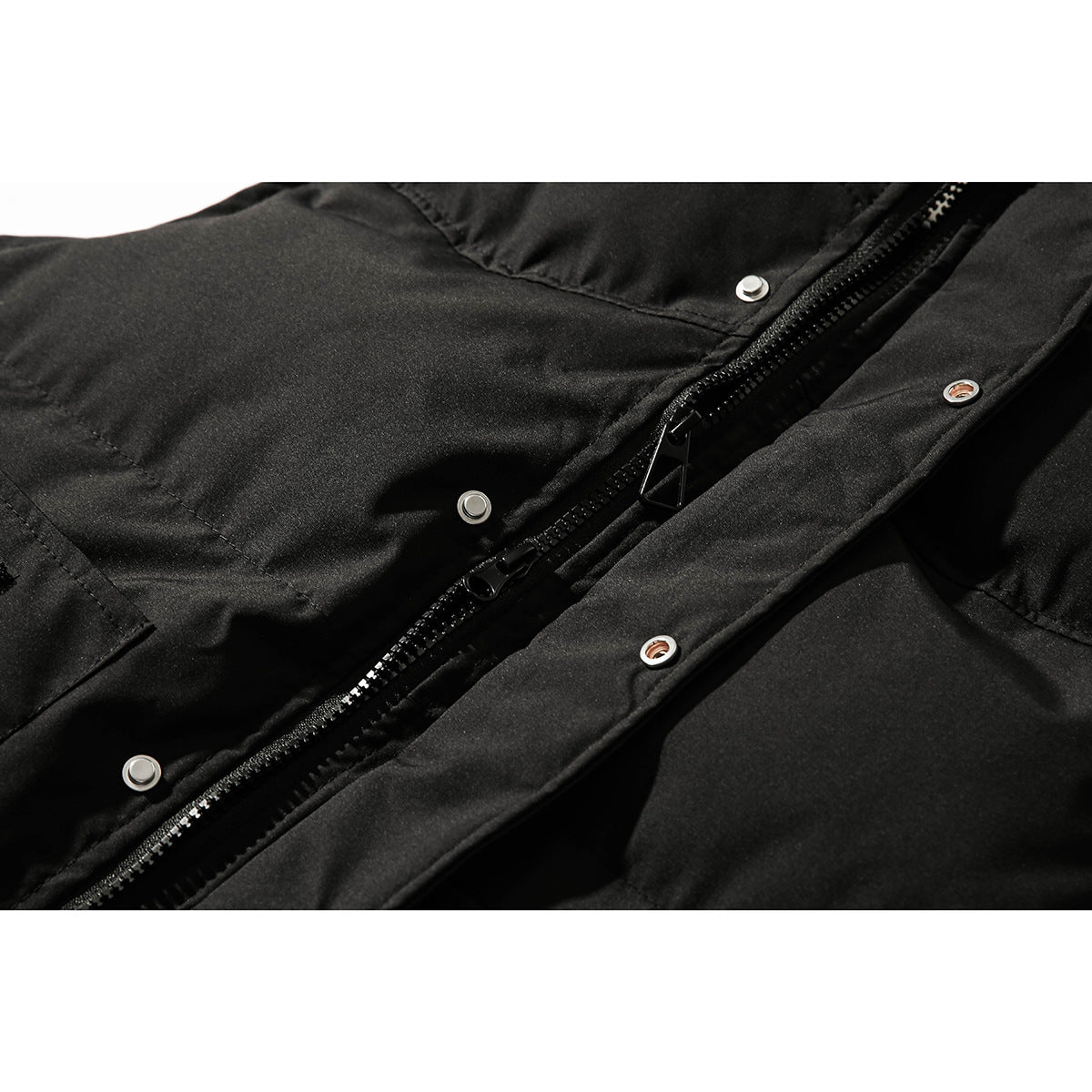 Close-up of a black jacket’s front zipper and snap-fastened storm flap.