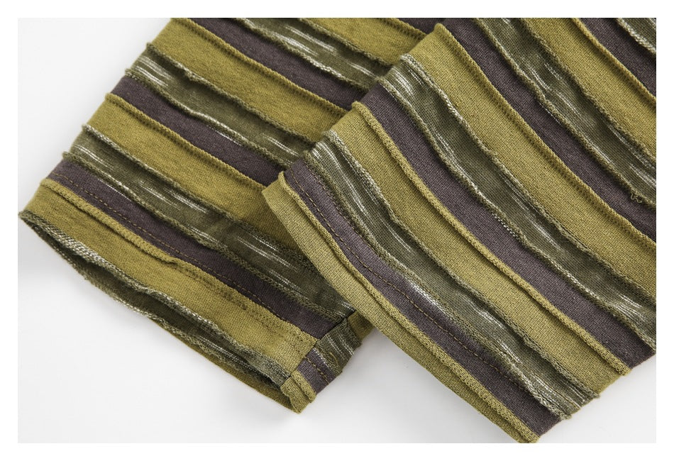 Close-up of folded edges and stitching on olive, brown, and textured green striped shirt fabric.