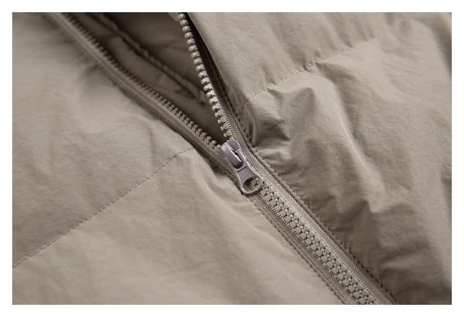 Close-up of a taupe jacket's chunky front zipper and stitching.